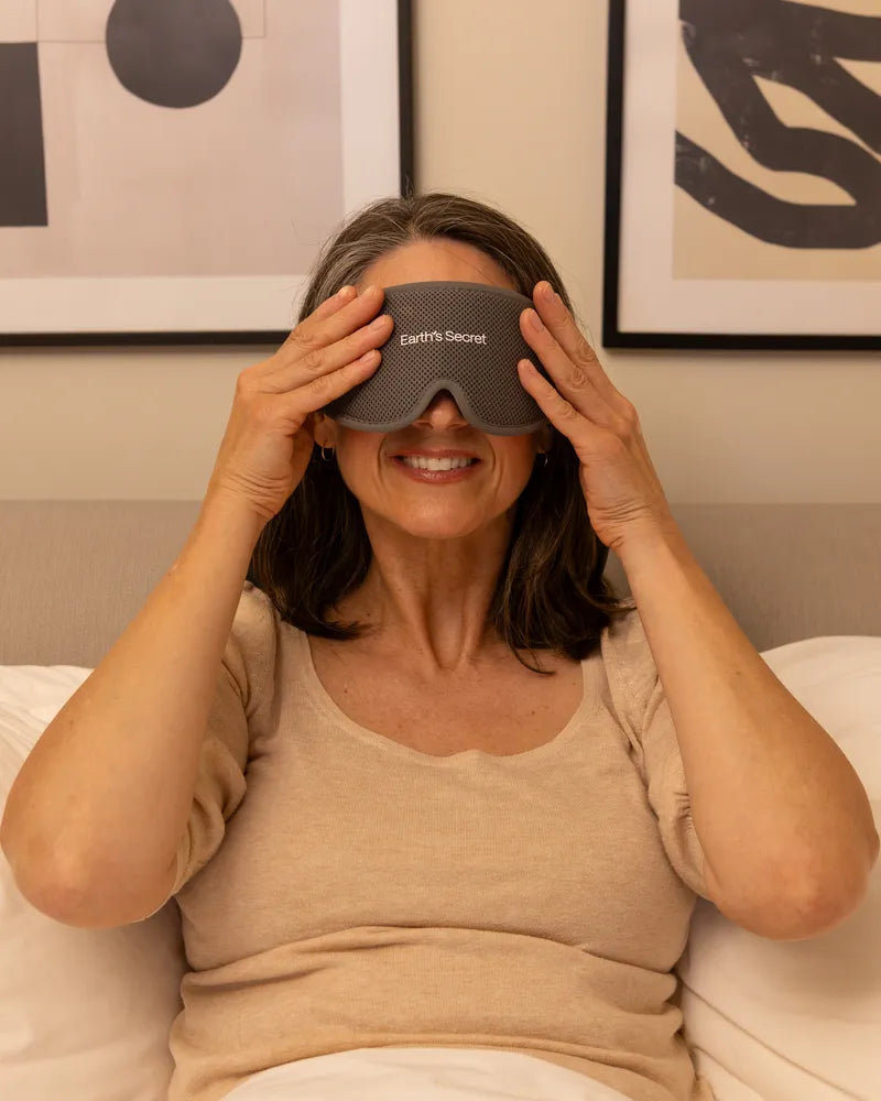 Woman in bed putting on the Dream sleep mask